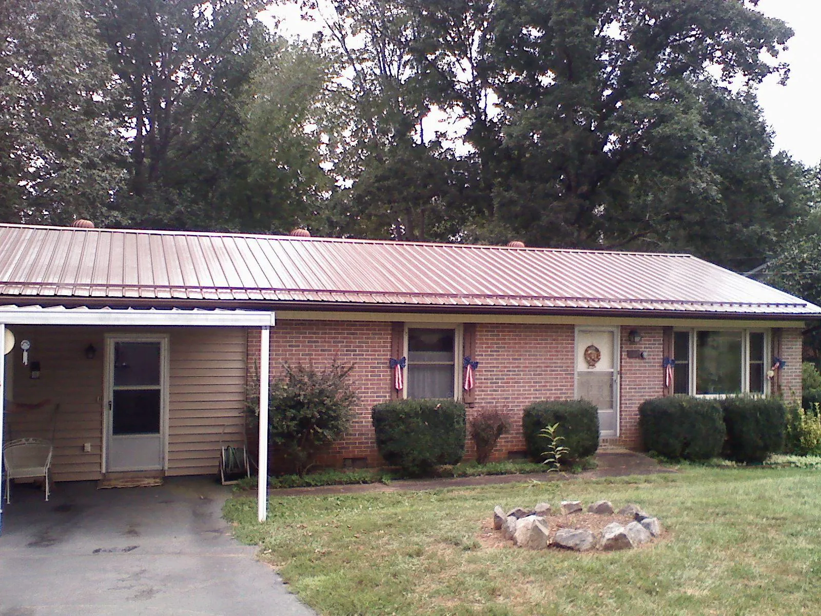 Bronze metal roof and carport on a brick ranch home — Roof Repair work by our crew in Pittsfield